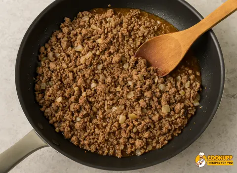 Ground beef and onions cooking in skillet for Alabama Hot Pocket filling