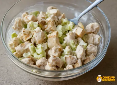 Mixed chicken salad with diced chicken and celery in creamy dressing, showing the fresh, blended ingredients.